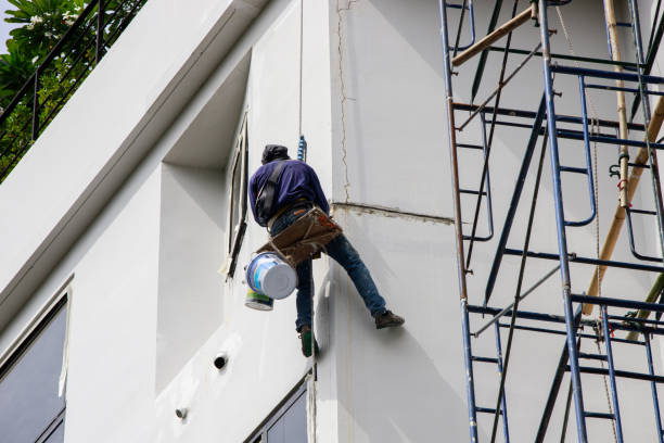 Asian Painter hanging by rope for fixing and painting exterior building wall. Selective focus.